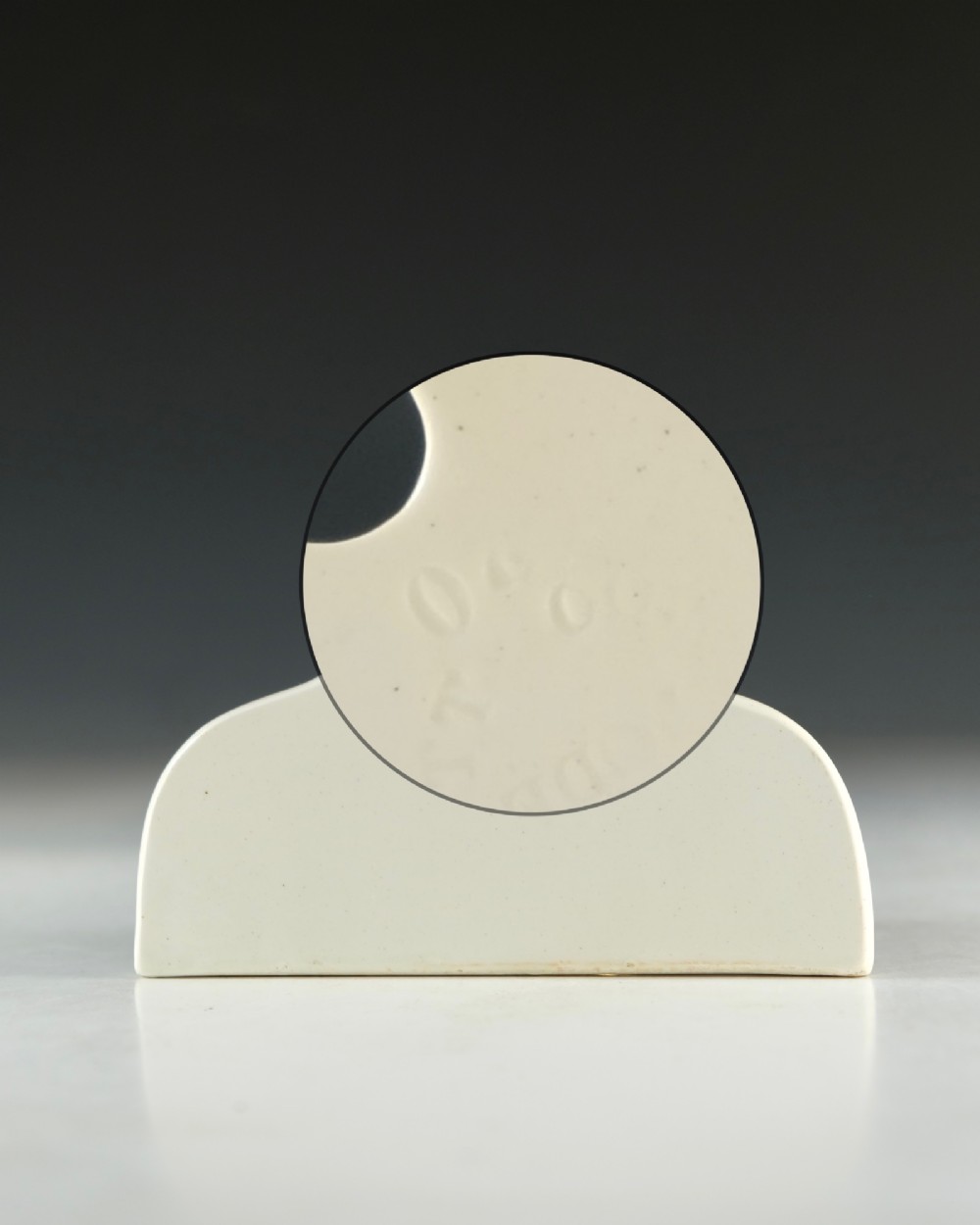 A mid-19th-century cream ceramic brandy bin label featuring black serif lettering and an arched crest with a central hanging hole. View IV