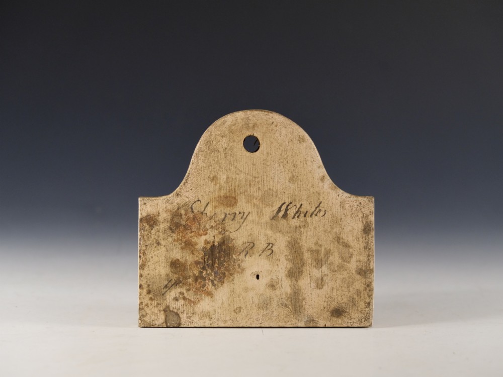 A mid 19th-century off-white creamware bin label with an arched top, suspension hole, and hand-written script reading Sherry Whites.