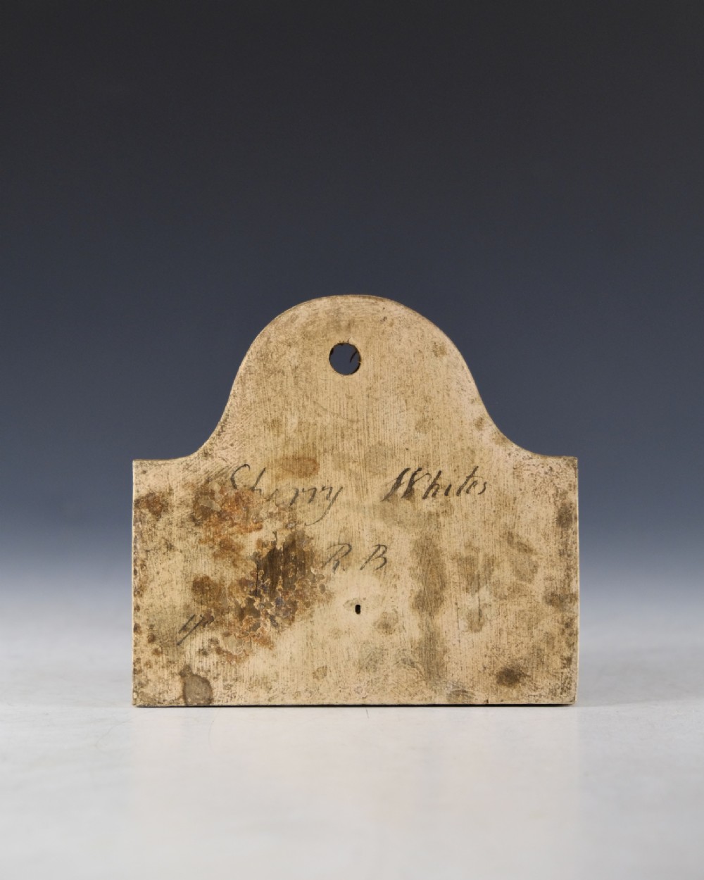 A mid 19th-century off-white creamware bin label with an arched top, suspension hole, and hand-written script reading Sherry Whites. View II