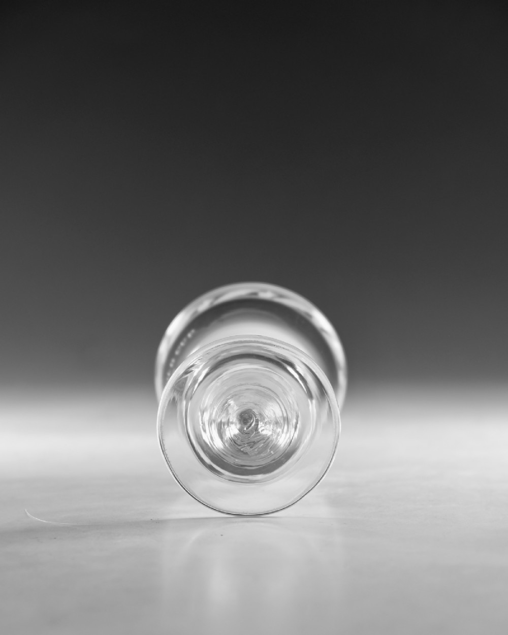 An antique clear glass Georgian rummer featuring wheel-engraved inscriptions and foliage motifs above a knopped stem. View VII