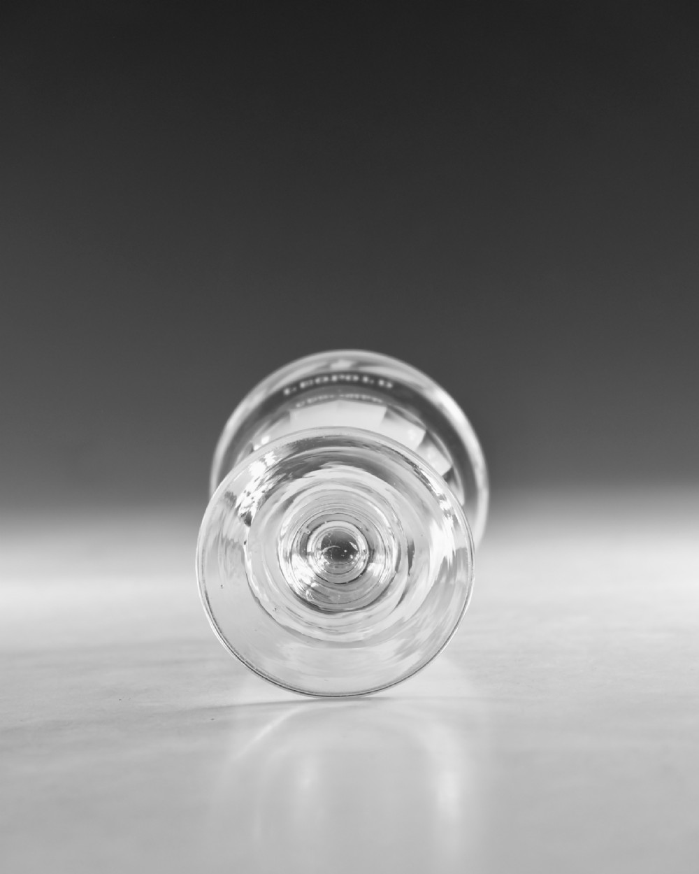 A clear Georgian lead crystal rummer glass featuring an engraved inscription reading LEOPOLD above a facet-cut lower bowl and knopped stem. View VI