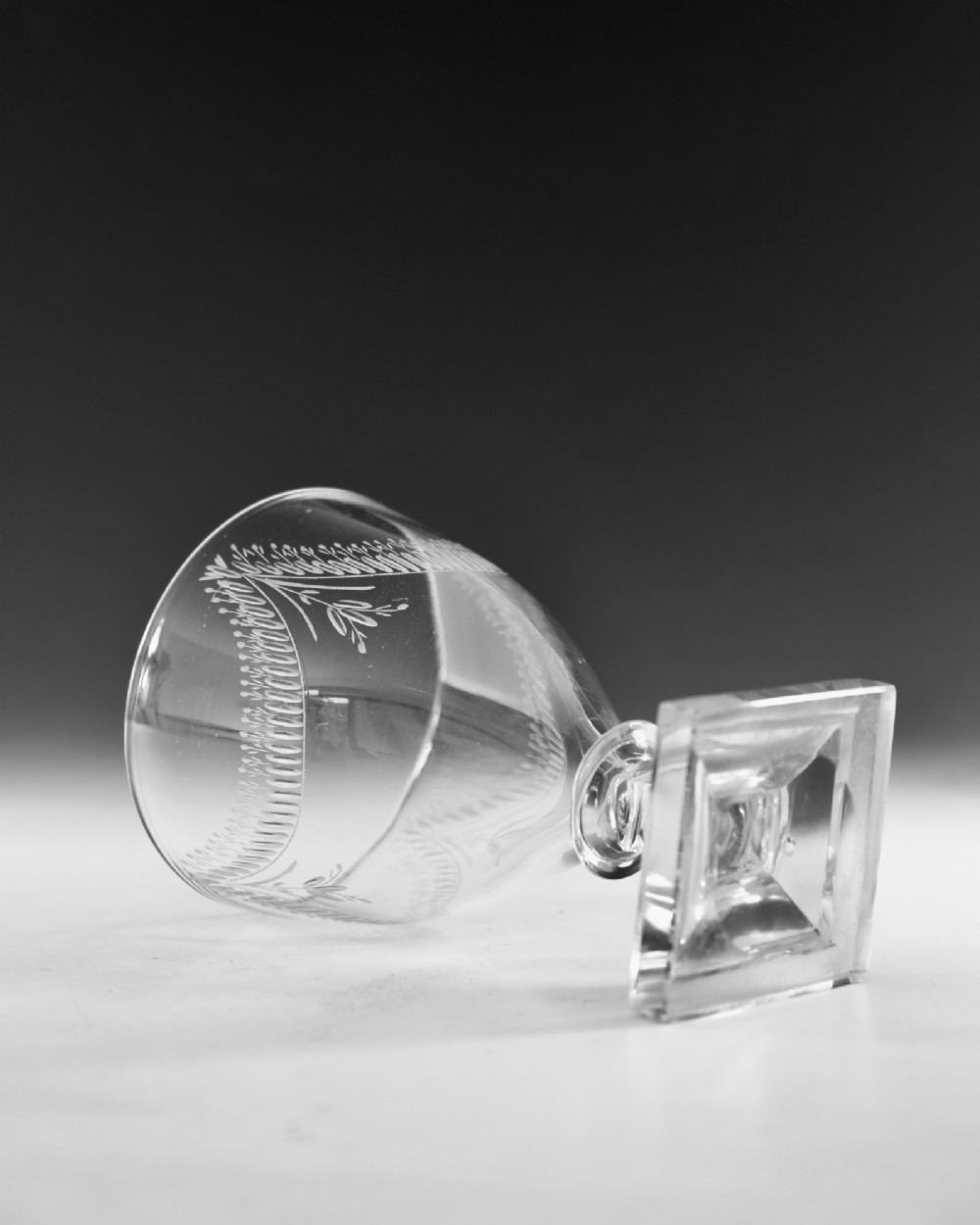 A Georgian clear glass rummer featuring an engraved festoon bowl on a square mould-pressed pedestal base. View IV