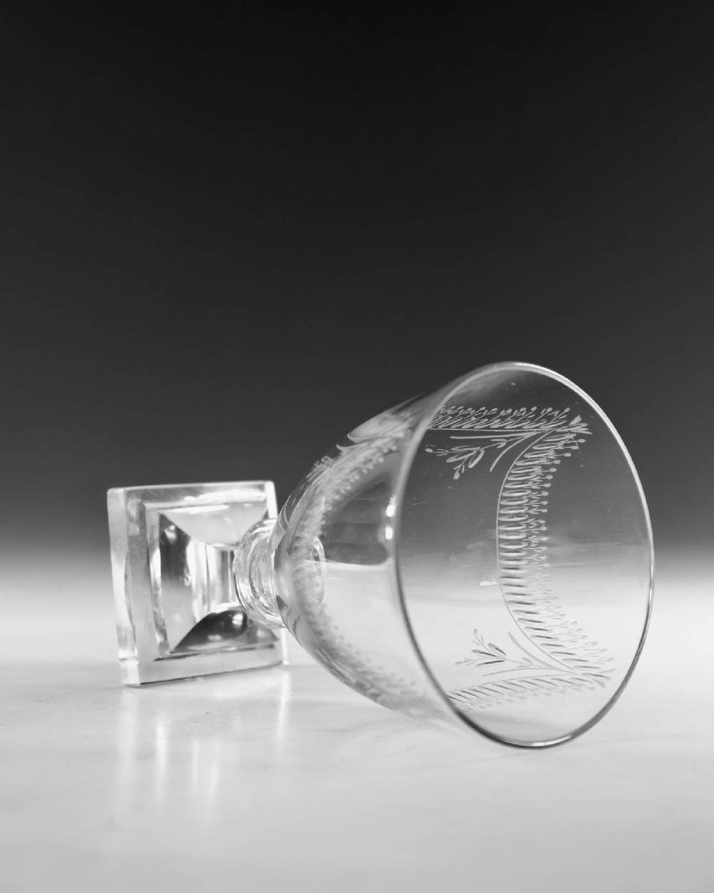A Georgian clear glass rummer featuring an engraved festoon bowl on a square mould-pressed pedestal base. View V