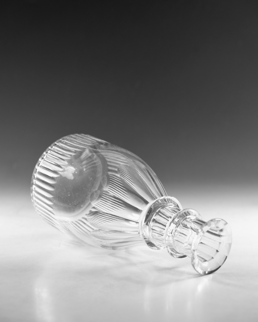 A clear Georgian cut-glass carafe featuring applied neck rings, petal cuts around the shoulder, and vertical fluting on the base. View IV