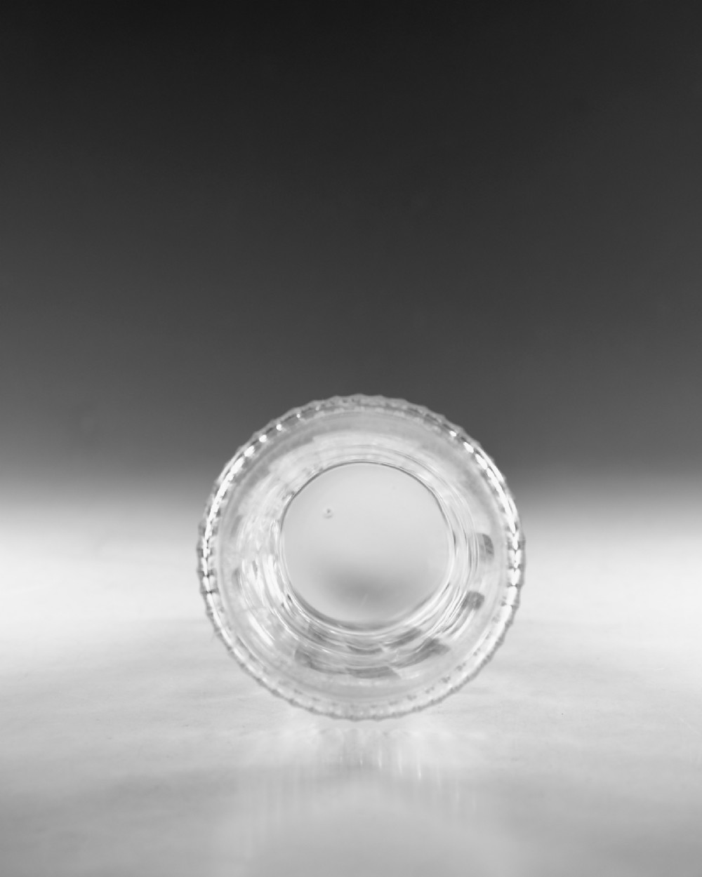 A clear Georgian cut-glass carafe featuring applied neck rings, petal cuts around the shoulder, and vertical fluting on the base. View V