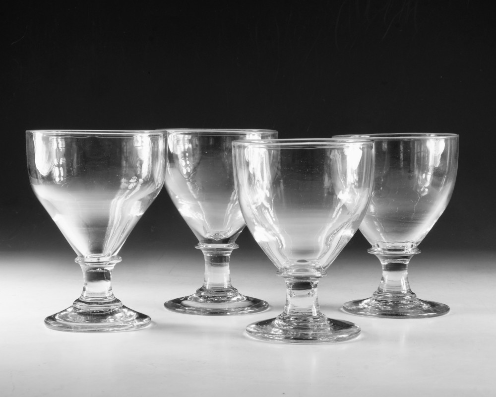 A set of four clear hand-blown Georgian glass rummers with wide funnel bowls, short collar stems, and circular flat bases. View VII