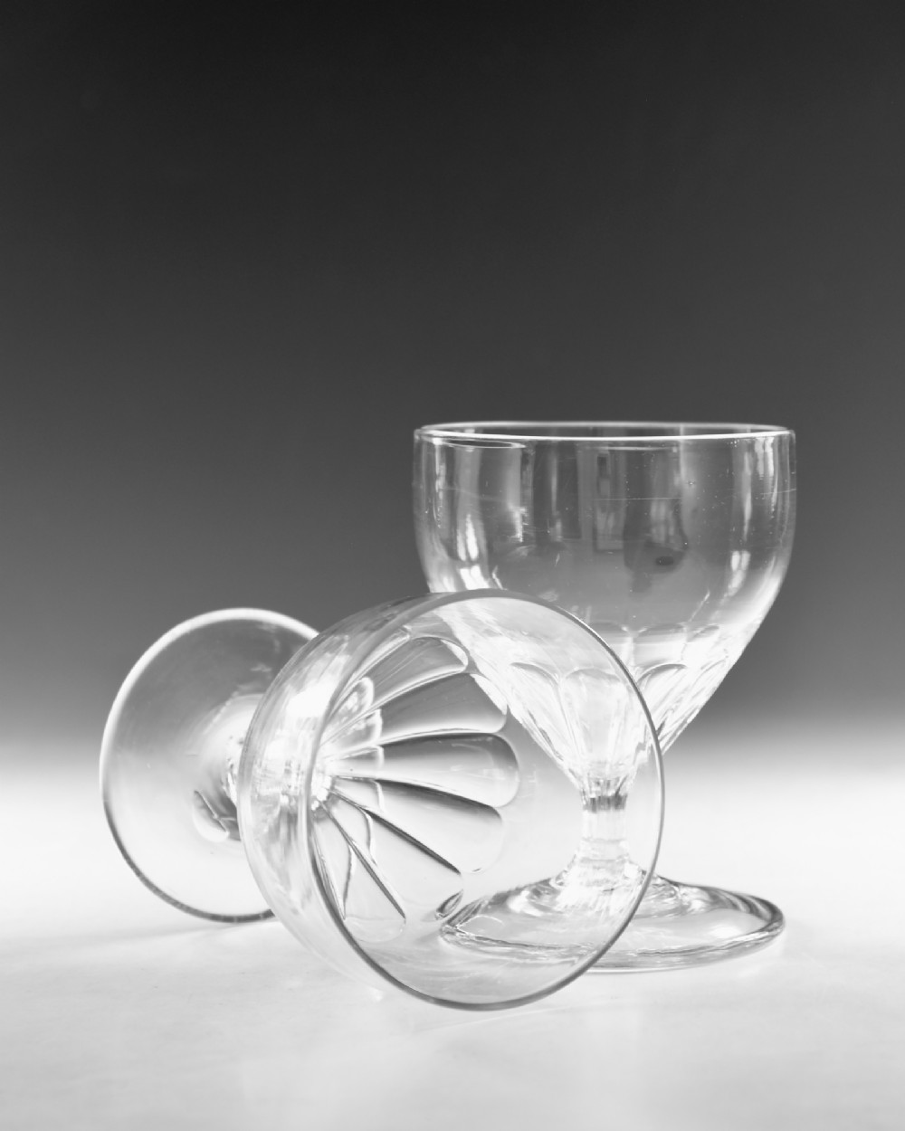A pair of antique Georgian clear glass rummers featuring wide cylindrical bowls with fluted lower panels on short stems and circular bases. View VII