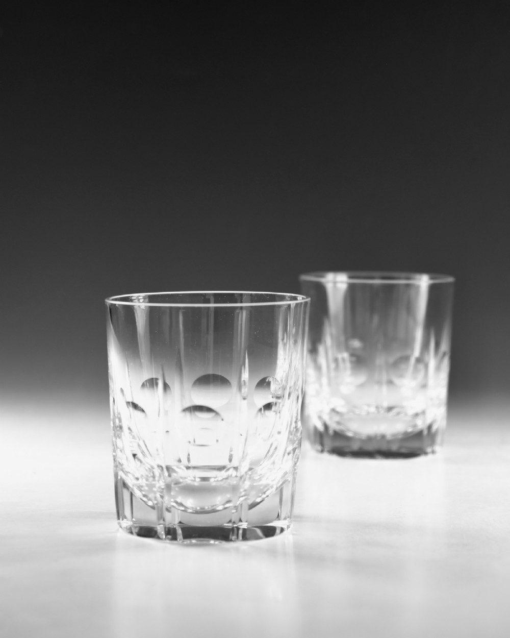 A pair of early twentieth-century clear cut glass tumblers featuring circular lens cuts and vertical fluting. View III