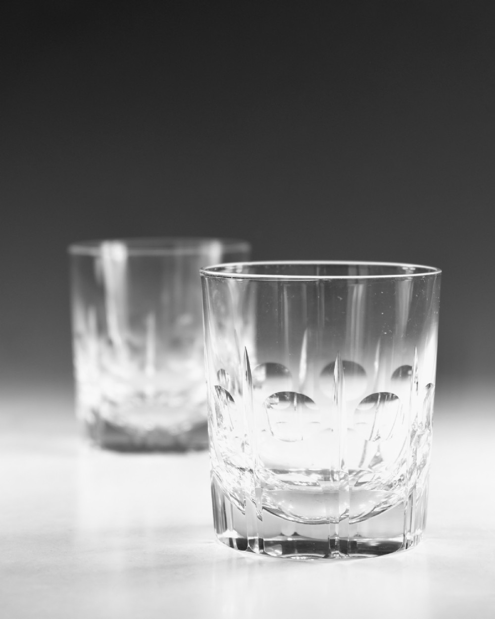 A pair of early twentieth-century clear cut glass tumblers featuring circular lens cuts and vertical fluting. View IV