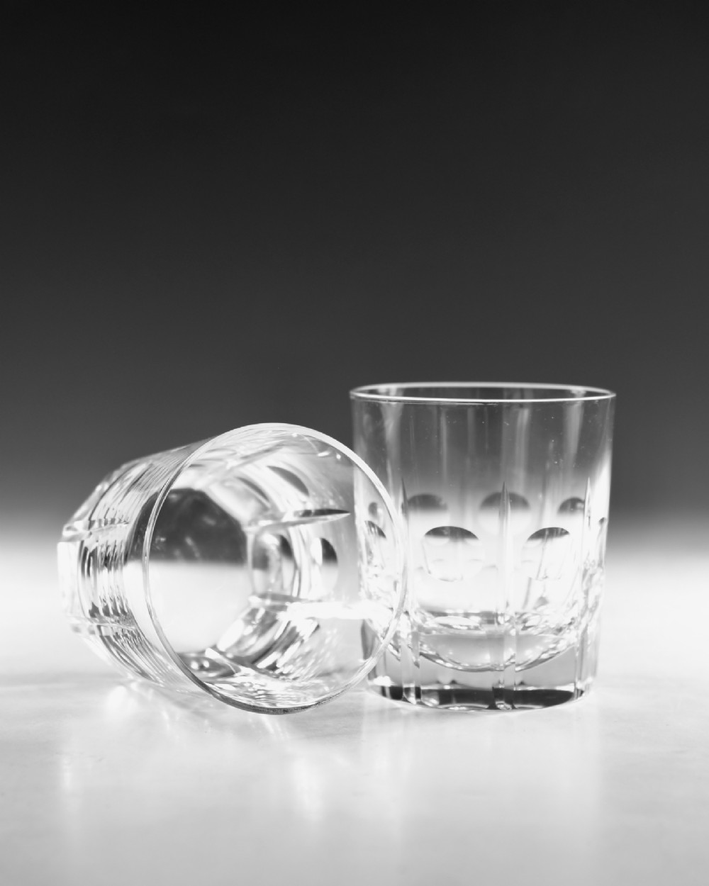 A pair of early twentieth-century clear cut glass tumblers featuring circular lens cuts and vertical fluting. View VI