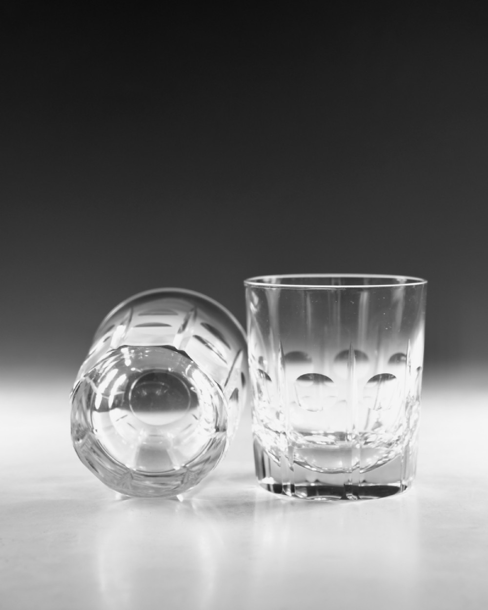 A pair of early twentieth-century clear cut glass tumblers featuring circular lens cuts and vertical fluting. View VII