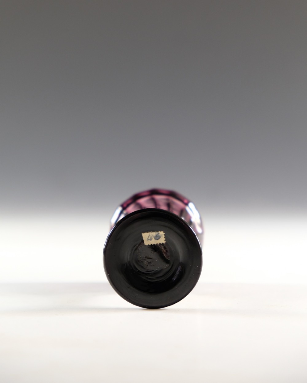 A Georgian amethyst purple glass egg cup with a fluted bowl, slender stem, and circular pedestal foot. View V