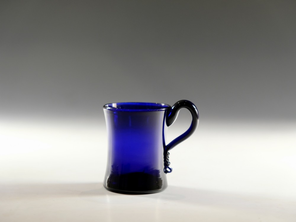 A small Georgian cobalt blue glass tankard with a curved applied handle and a flared base. View VI