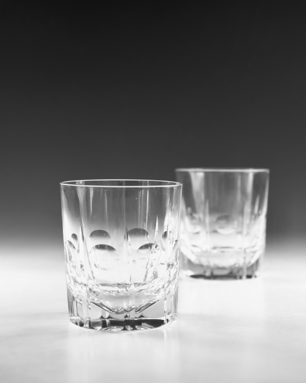 A pair of clear cut-glass tumblers featuring circular printie cuts and vertical faceted lines around the lower body. View III