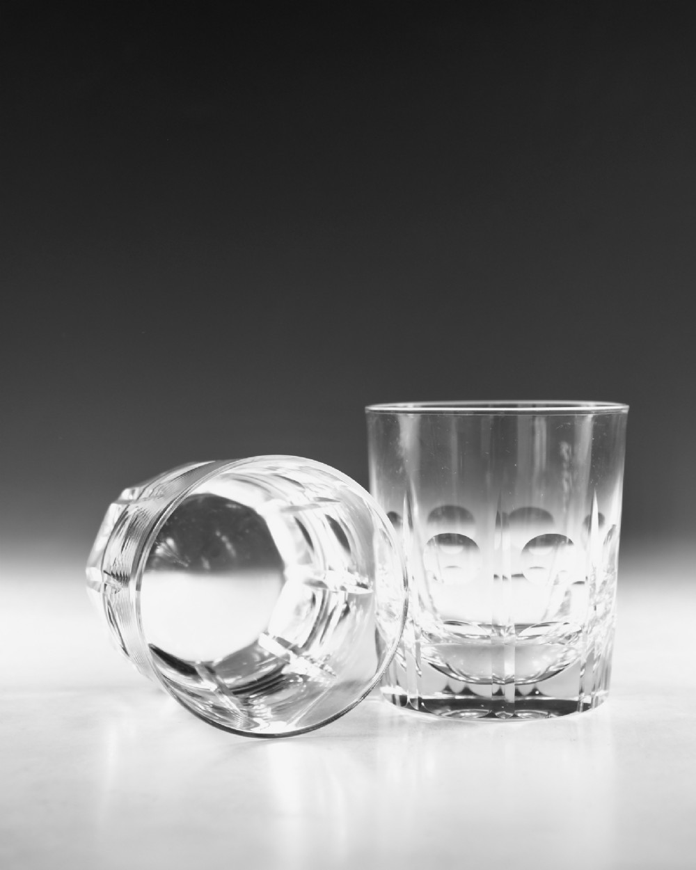 A pair of clear cut-glass tumblers featuring circular printie cuts and vertical faceted lines around the lower body. View VI