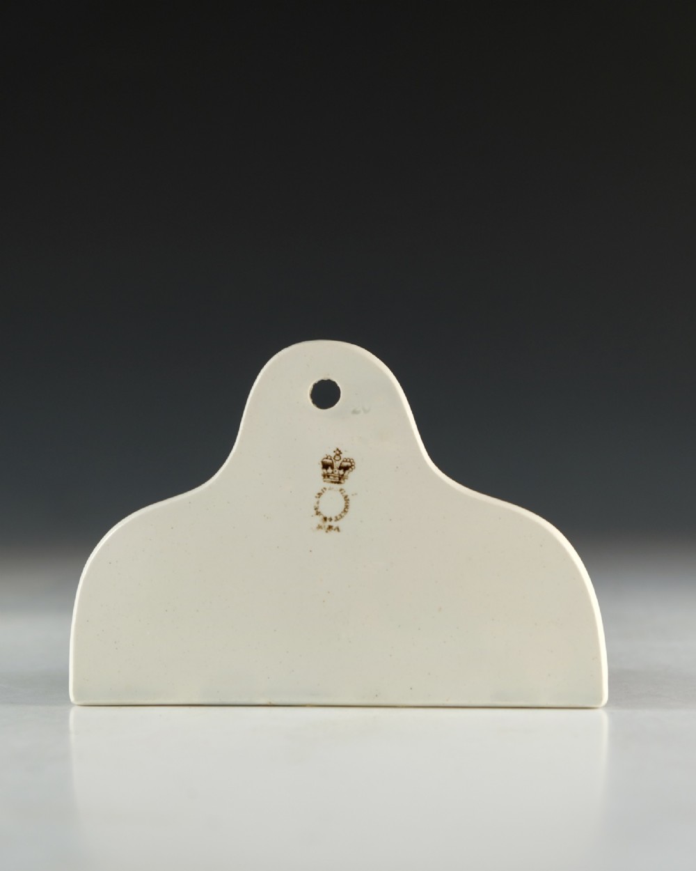 A cream glazed ceramic wine bin label with an arched top, single hanging hole, and black printed serif text reading HOCK. View III