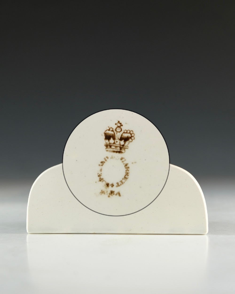 A cream glazed ceramic wine bin label with an arched top, single hanging hole, and black printed serif text reading HOCK. View IV