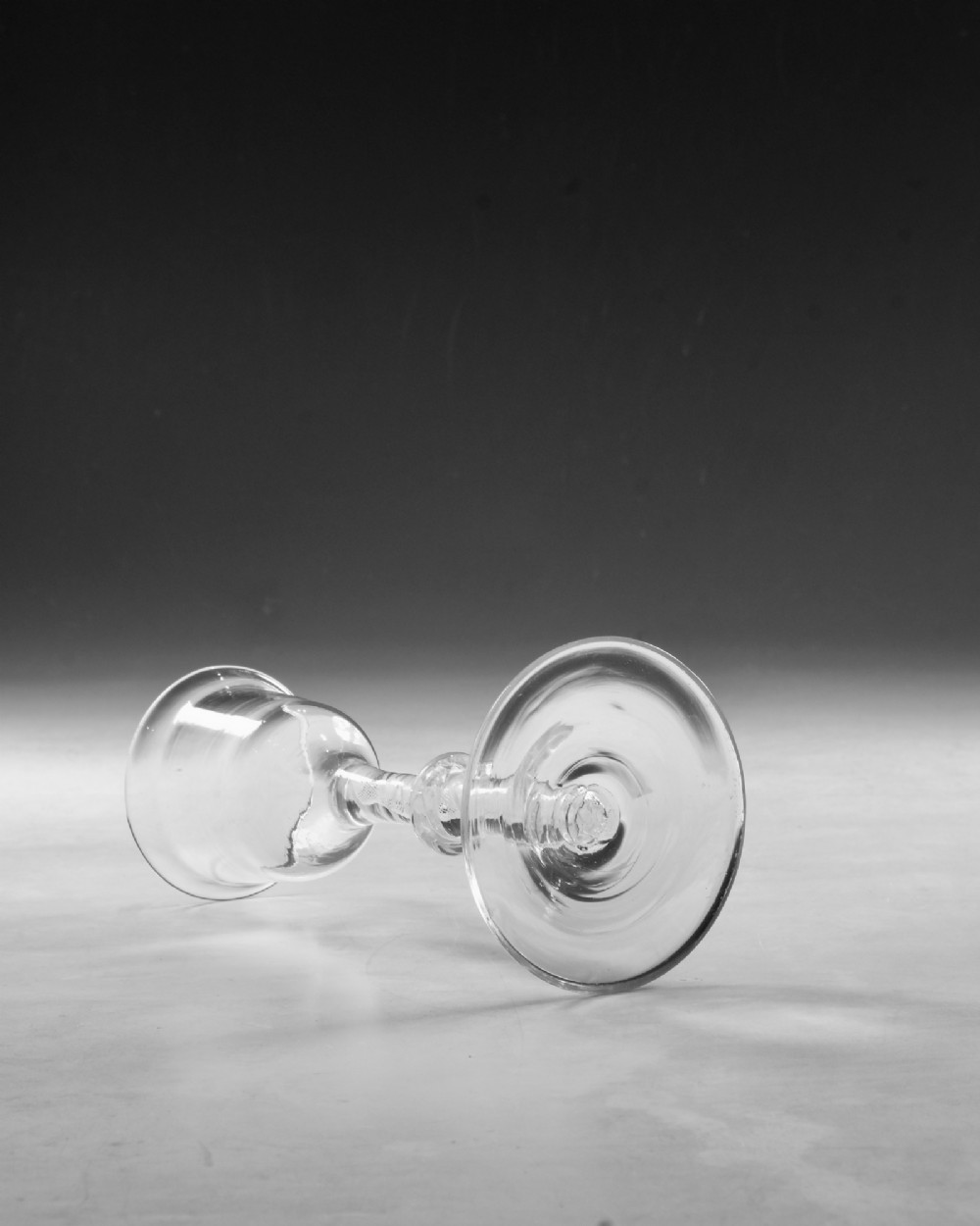 A Georgian clear lead glass wine glass featuring a bell-shaped bowl and a knopped stem with an internal white opaque twist pattern on a conical foot. View IV