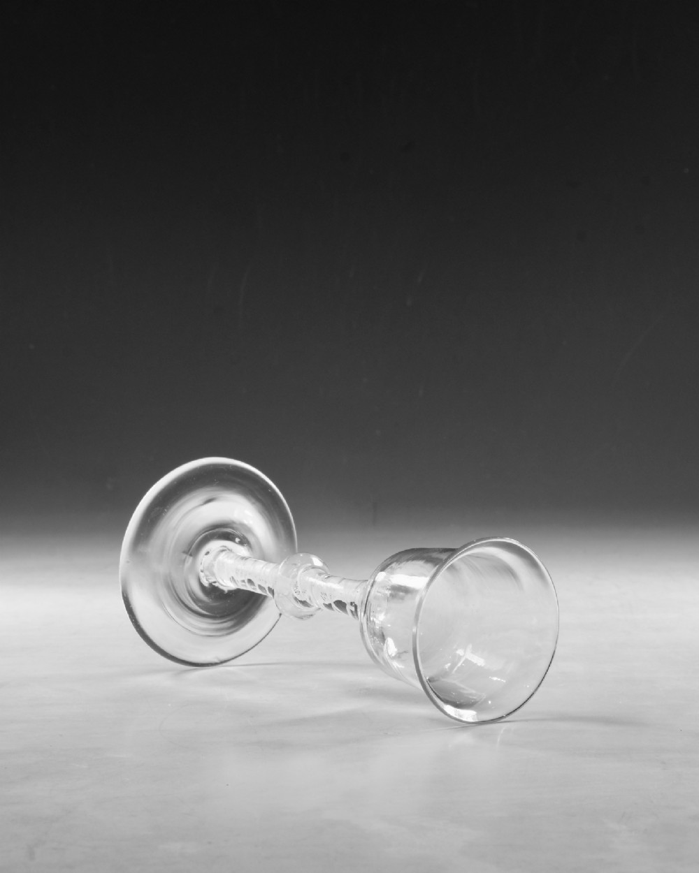 A Georgian clear lead glass wine glass featuring a bell-shaped bowl and a knopped stem with an internal white opaque twist pattern on a conical foot. View V