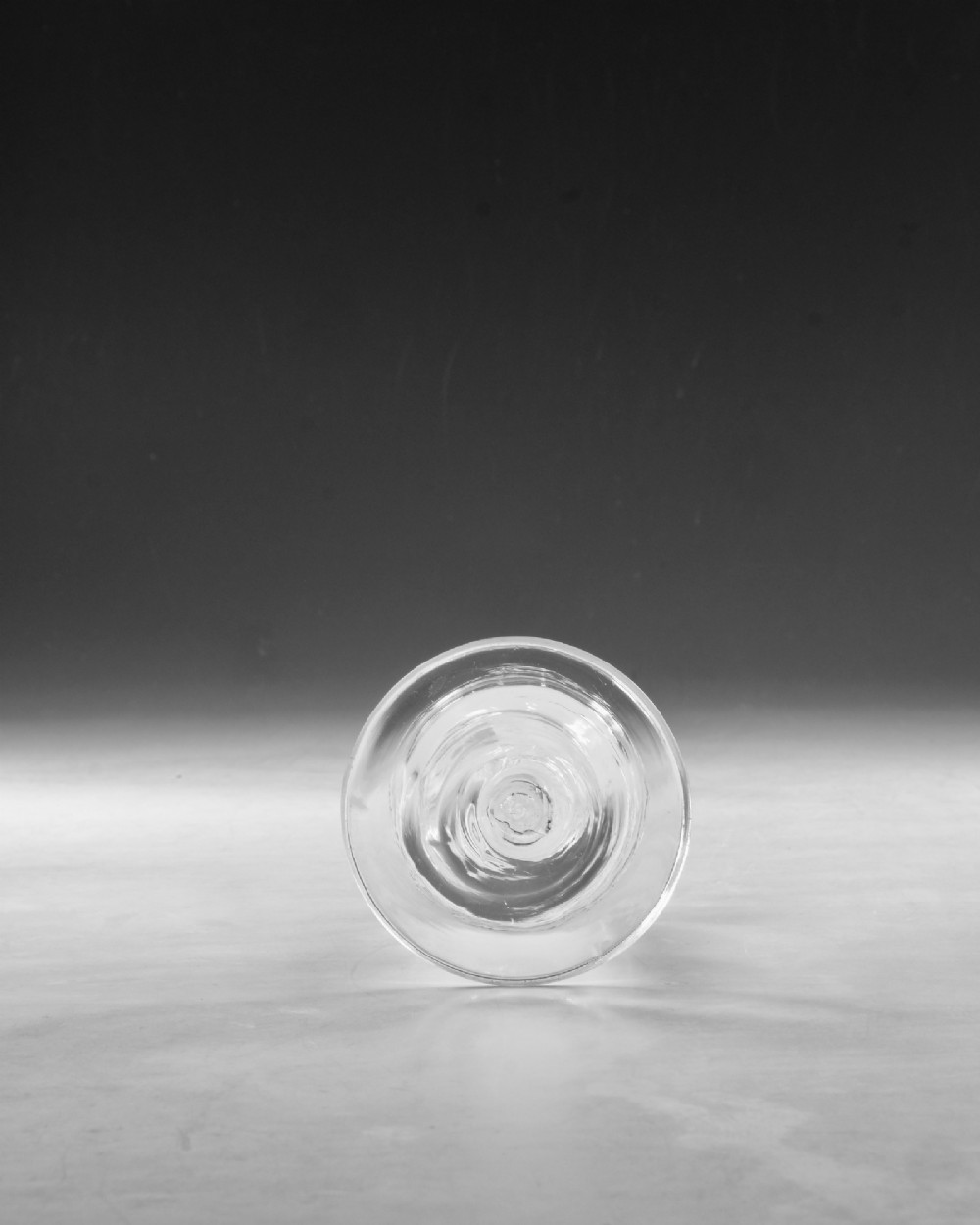 A Georgian clear lead glass wine glass featuring a bell-shaped bowl and a knopped stem with an internal white opaque twist pattern on a conical foot. View VI