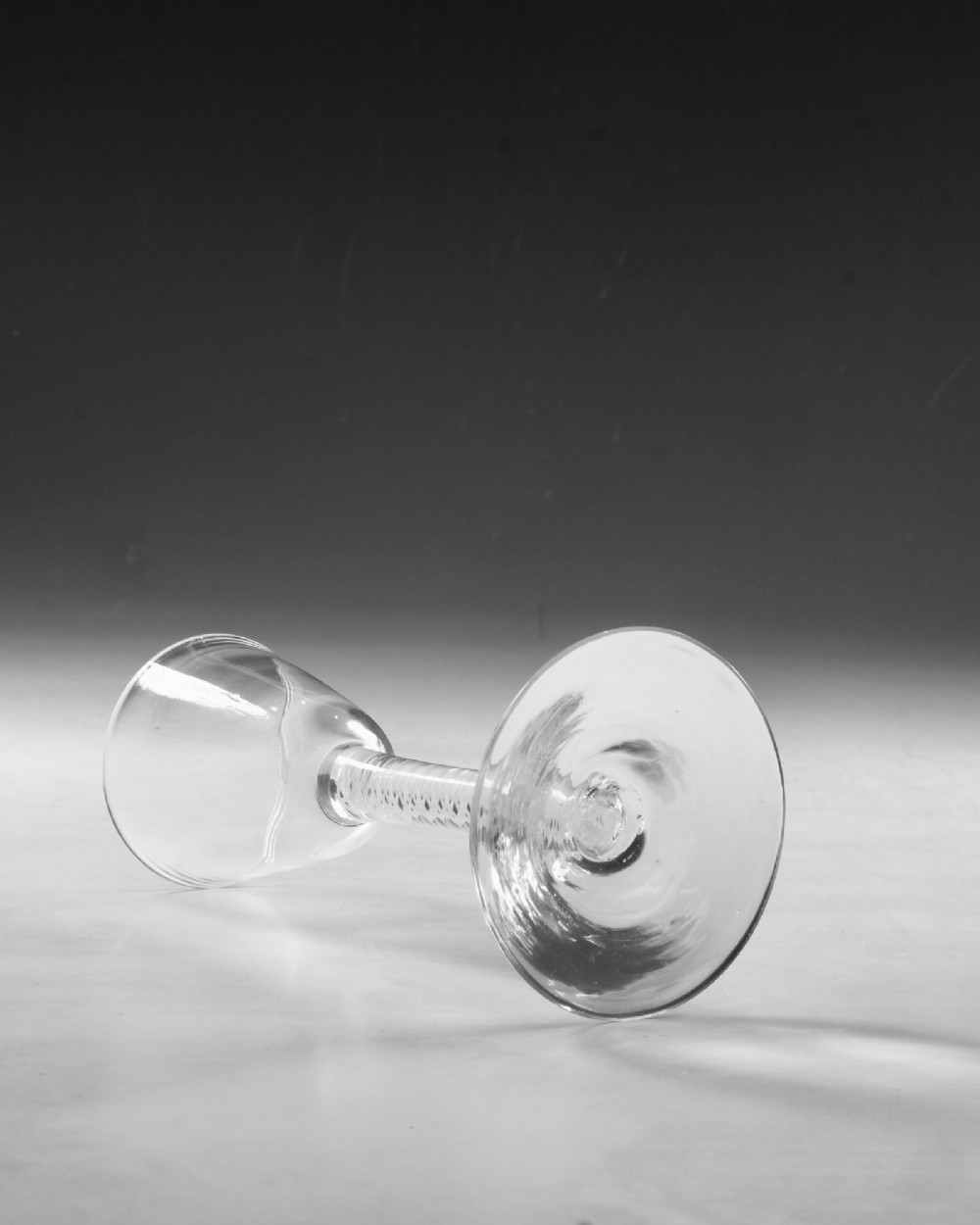 A Georgian clear lead crystal wine glass featuring a bell-shaped bowl, a stem with an internal white opaque twist pattern, and a conical foot. View III