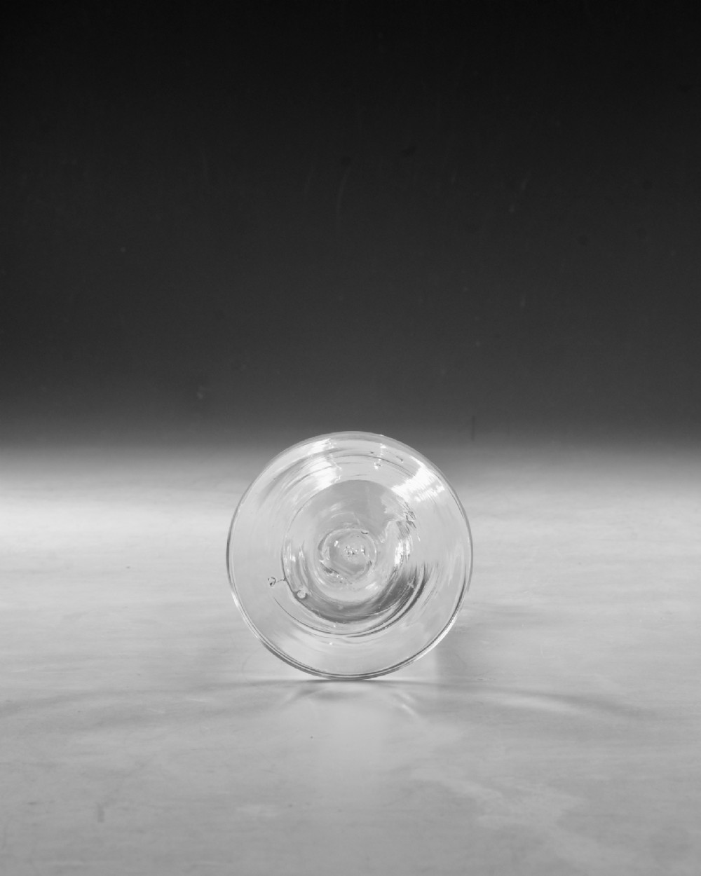 An 18th-century Georgian clear glass wine goblet featuring a wheel-engraved floral bowl, an internal opaque white twist stem, and a flat conical base. View VI