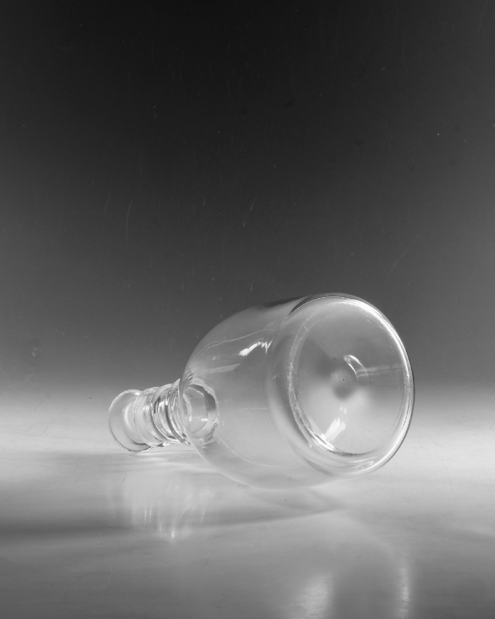 A clear Georgian glass decanter featuring three applied neck rings and a flat circular stopper. View IV