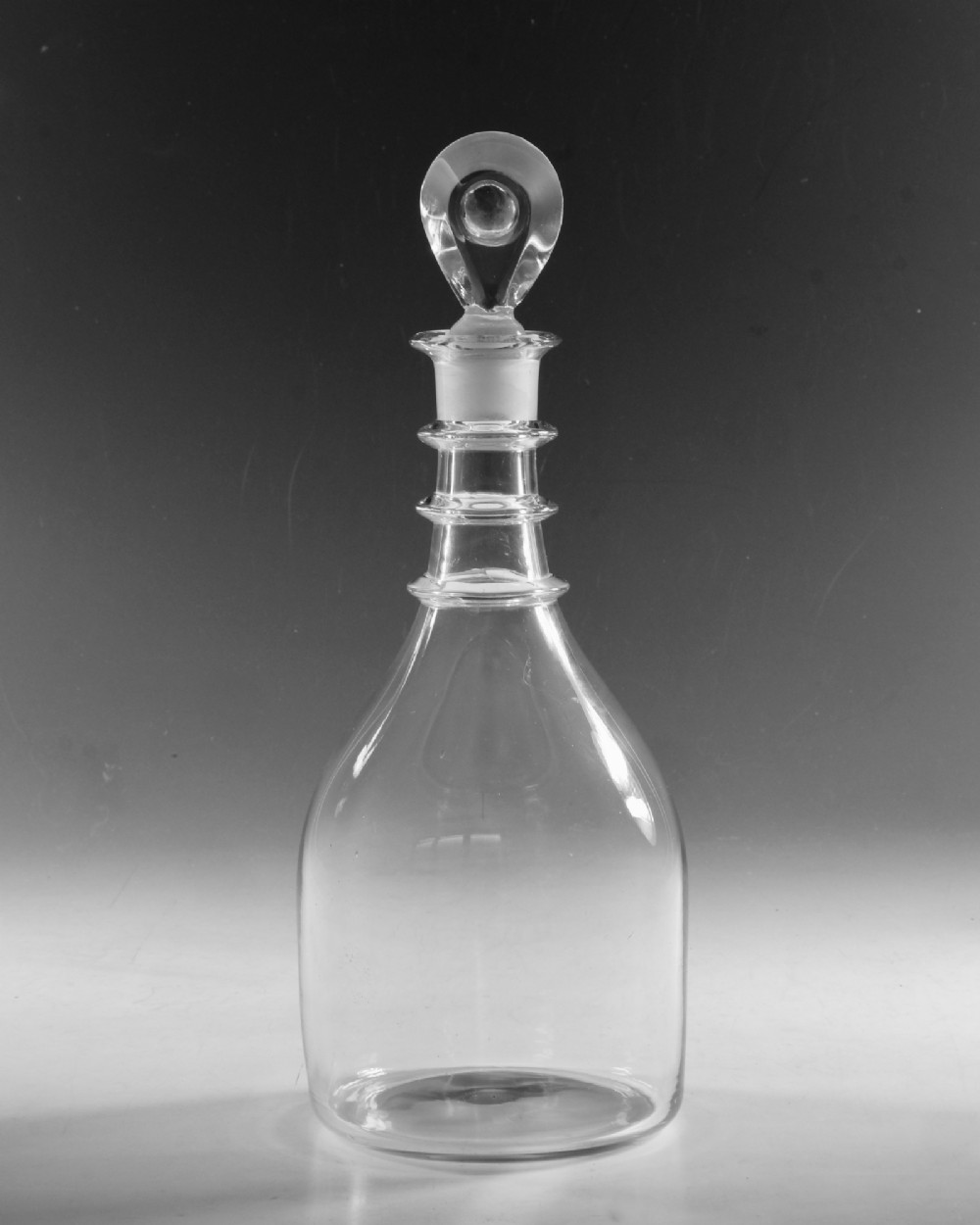 A clear Georgian glass decanter featuring three applied neck rings and a flat circular stopper. View VII