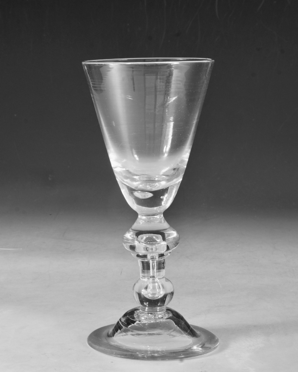 A hand-blown clear lead glass baluster wine goblet featuring a bell bowl, knopped stem with an air tear inclusion, and a folded conical foot. View VII
