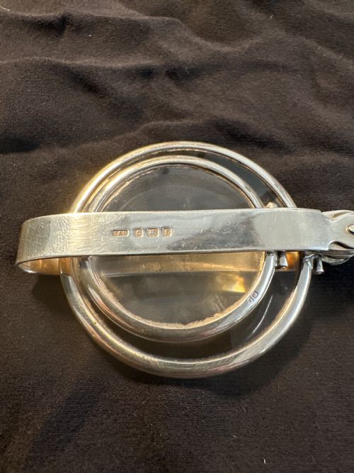 fig 1. An Edwardian hallmarked sterling silver folding double-lens magnifying glass with two circular lenses attached to a hinged handle.