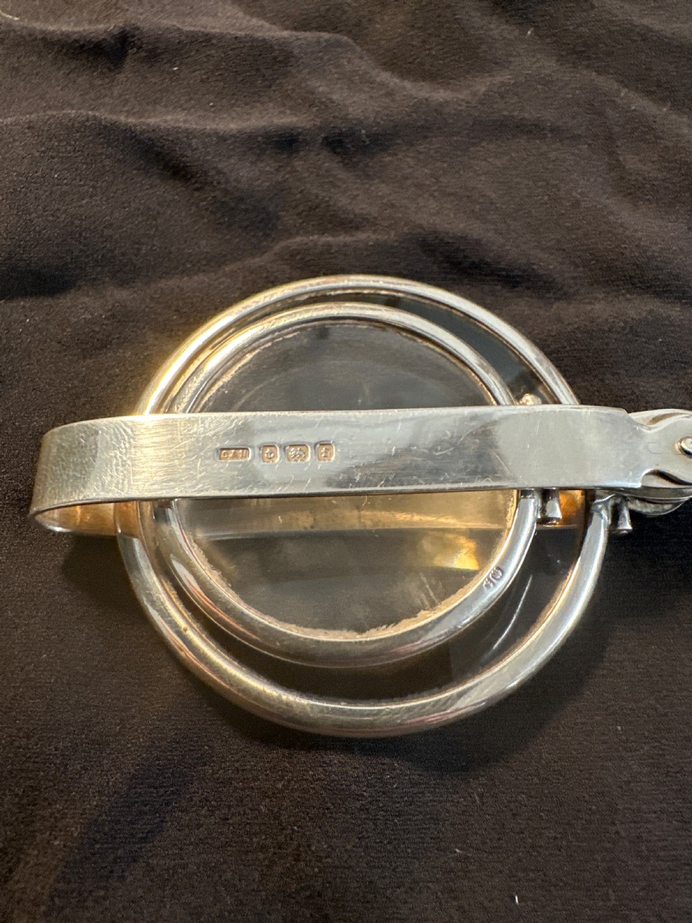 An Edwardian hallmarked sterling silver folding double-lens magnifying glass with two circular lenses attached to a hinged handle. View II