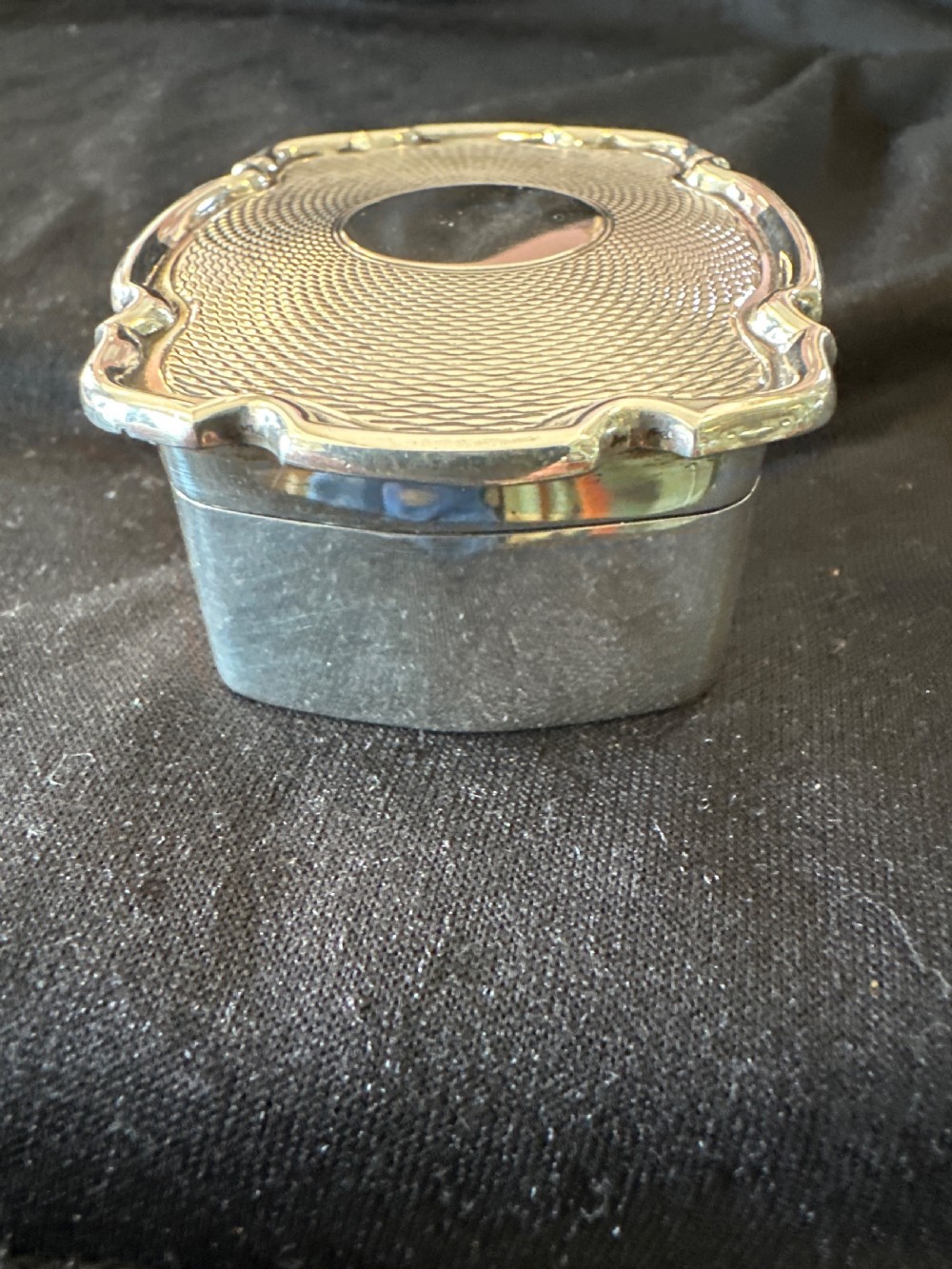 An Edwardian sterling silver shaped box with engine-turned geometric detailing on the lid and a central plain circular cartouche. View III