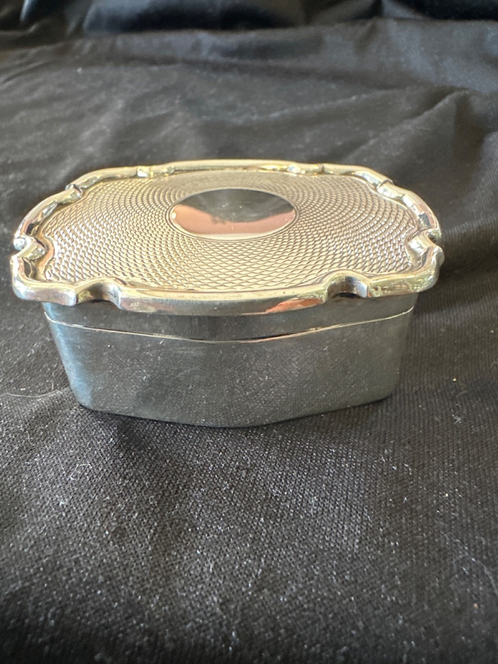 An Edwardian sterling silver shaped box with engine-turned geometric detailing on the lid and a central plain circular cartouche. View IV