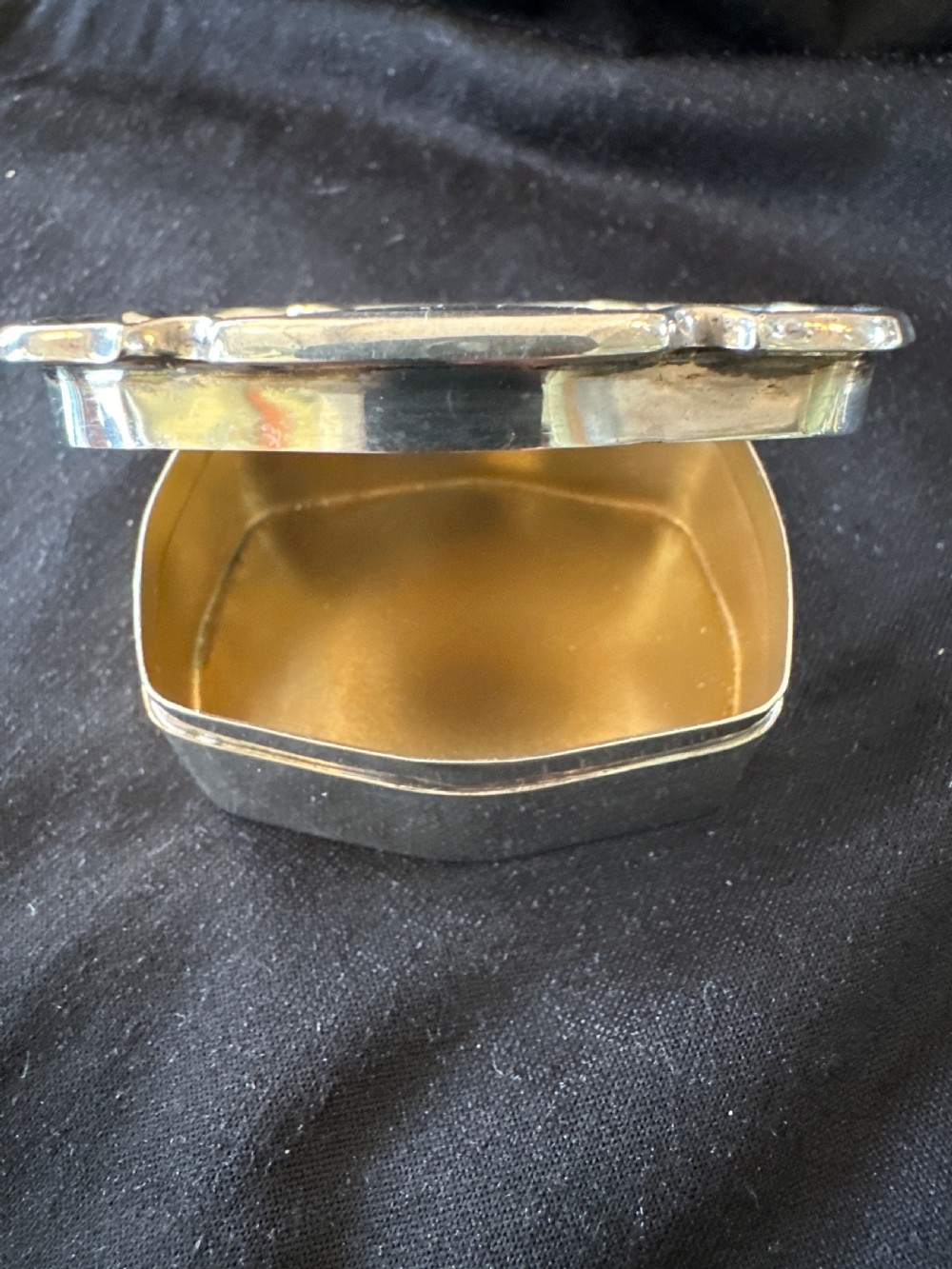 An Edwardian sterling silver shaped box with engine-turned geometric detailing on the lid and a central plain circular cartouche. View VII
