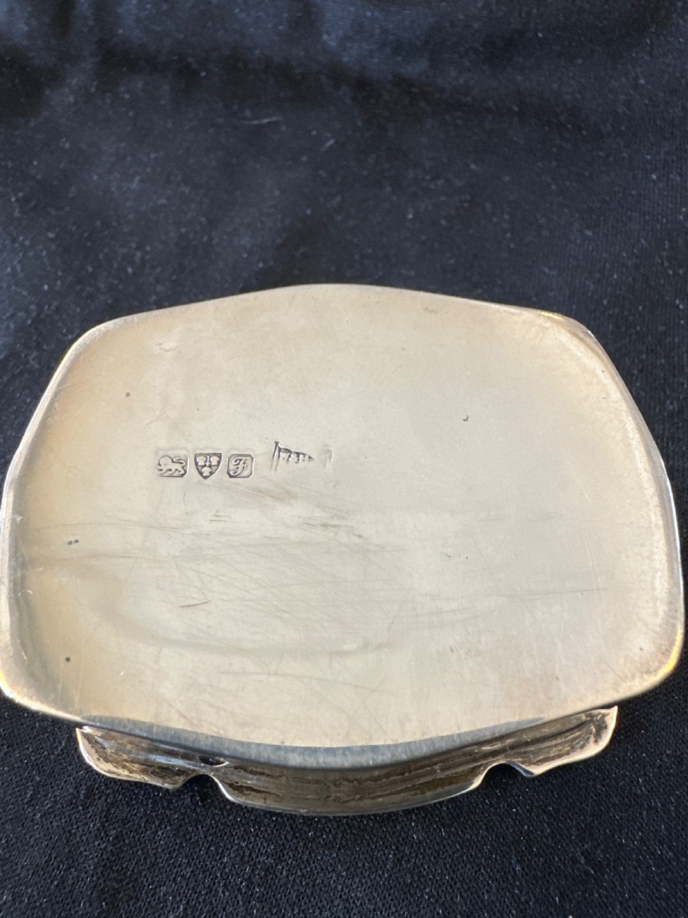 An Edwardian sterling silver shaped box with engine-turned geometric detailing on the lid and a central plain circular cartouche. View X