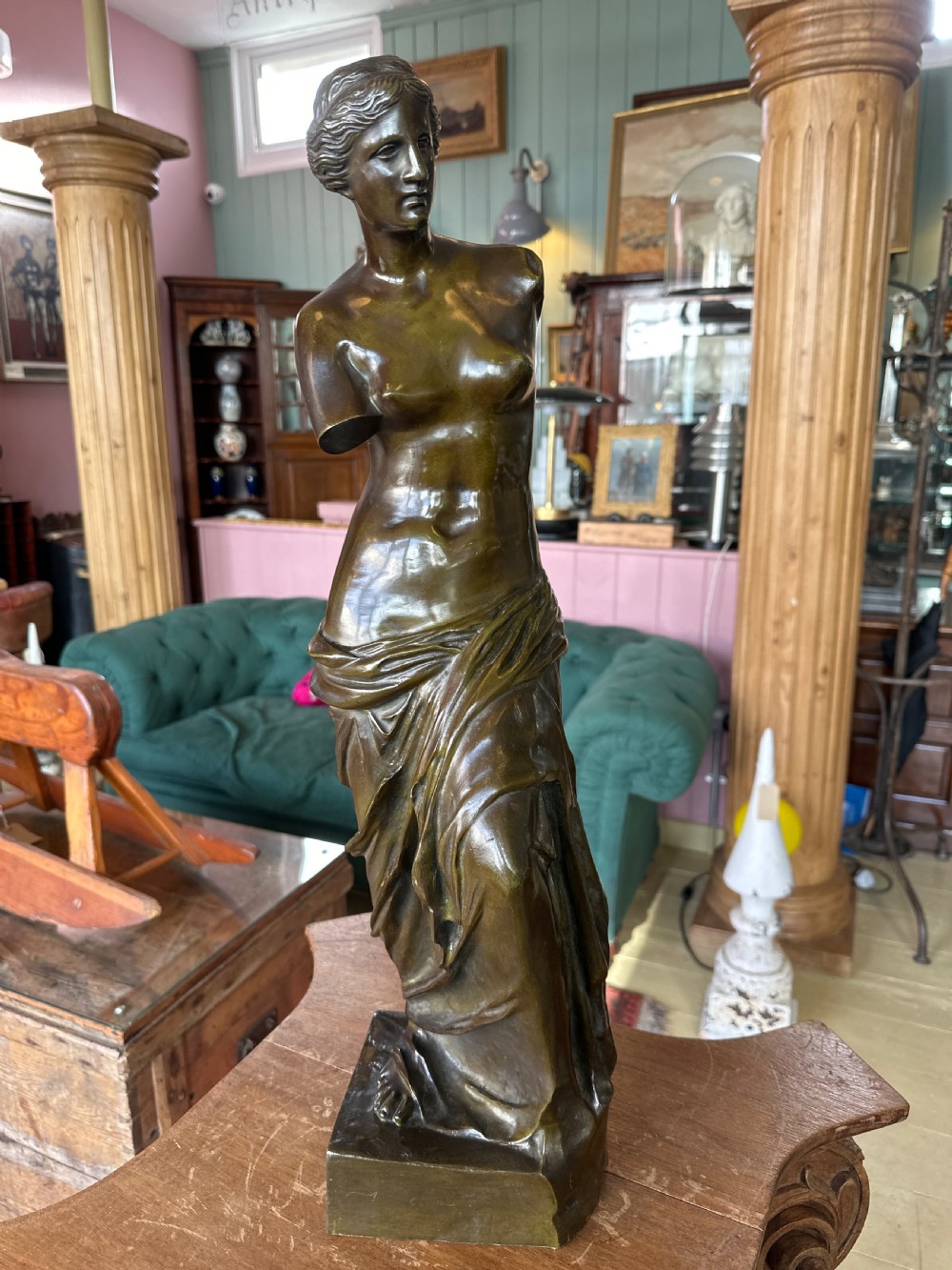 A 19th-century dark brown bronze sculpture depicting the Venus de Milo standing on an integral rectangular base.