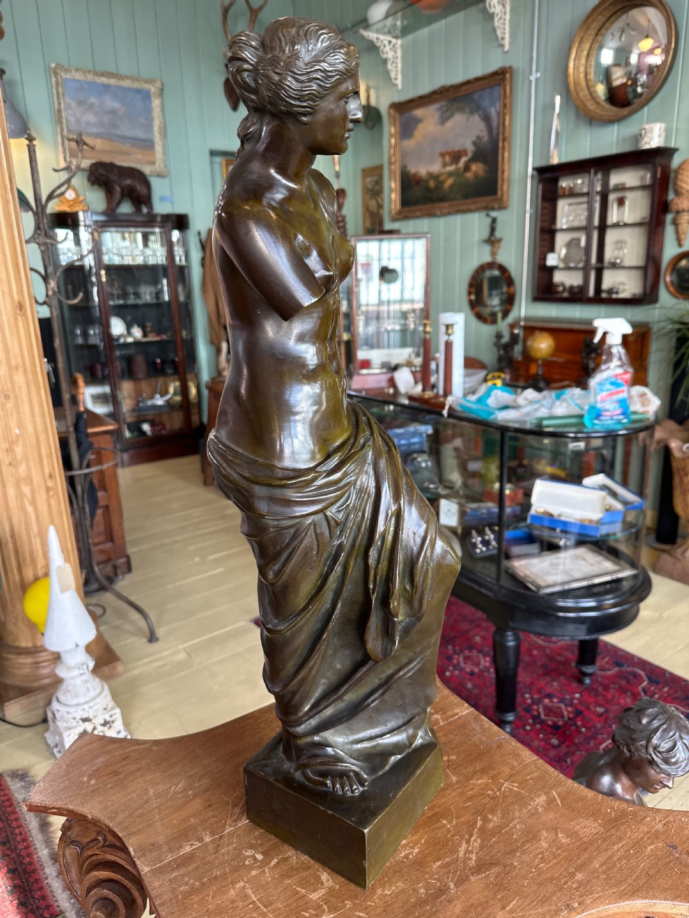 A 19th-century dark brown bronze sculpture depicting the Venus de Milo standing on an integral rectangular base. View II