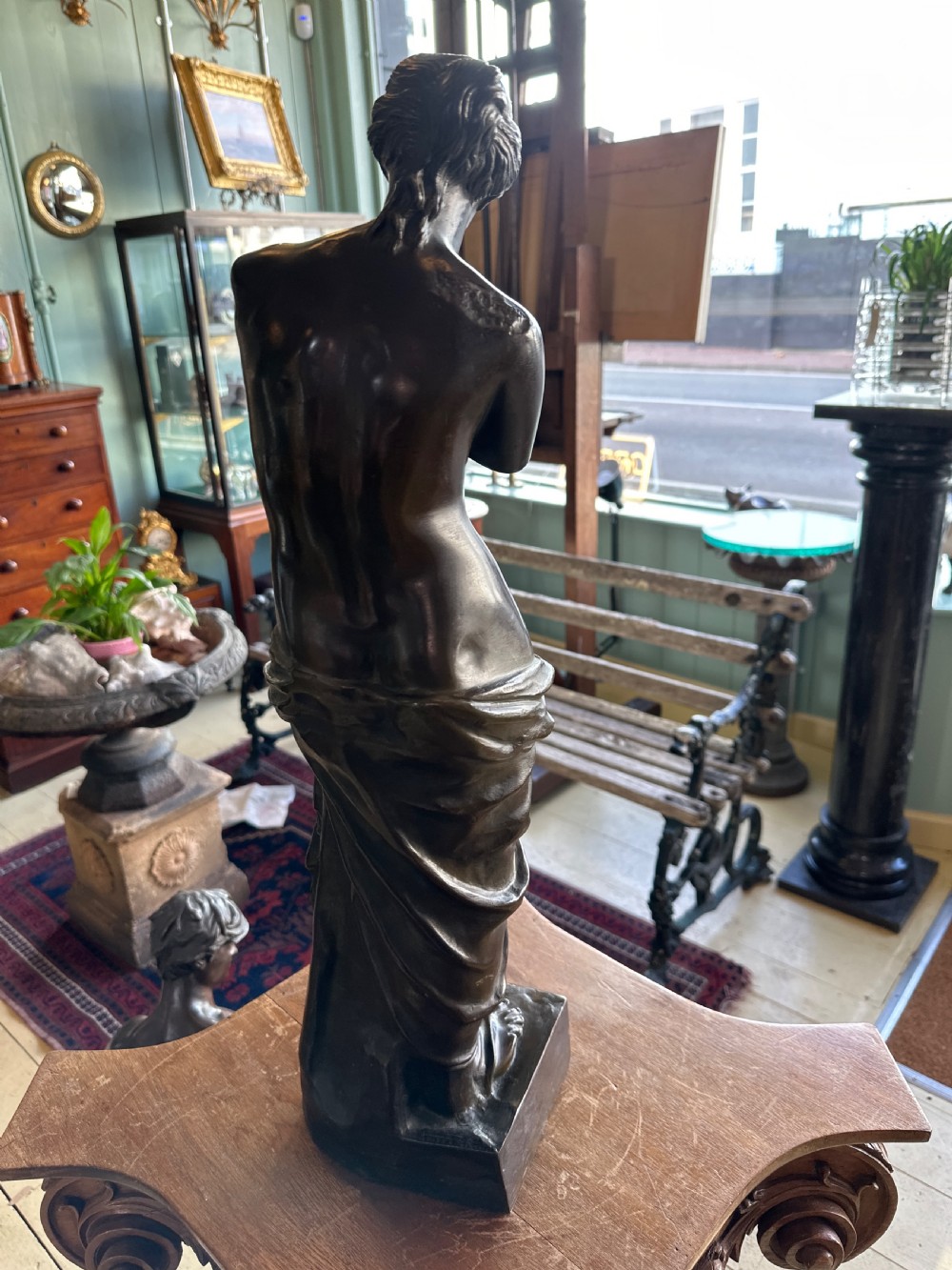 A 19th-century dark brown bronze sculpture depicting the Venus de Milo standing on an integral rectangular base. View III