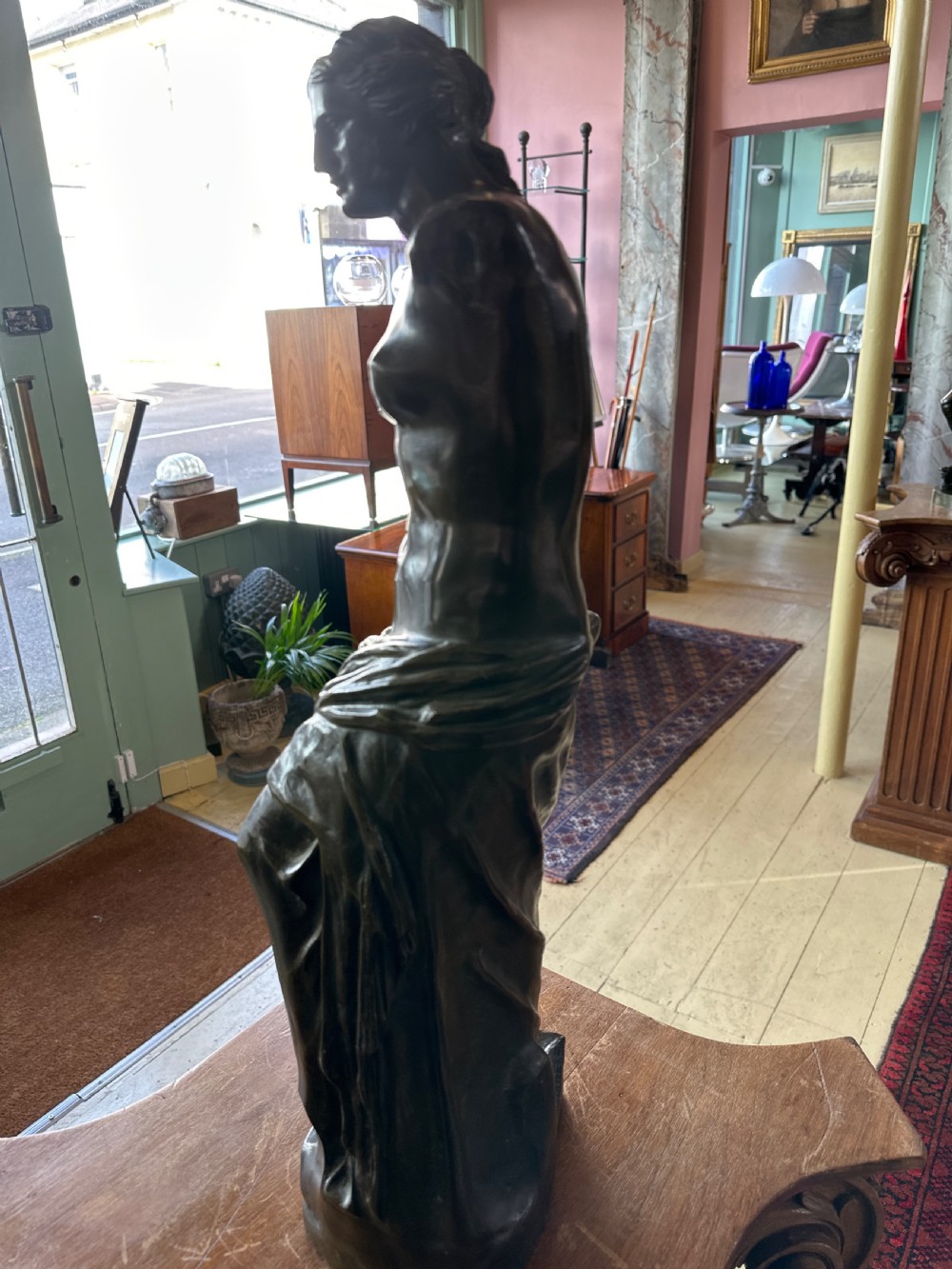 A 19th-century dark brown bronze sculpture depicting the Venus de Milo standing on an integral rectangular base. View IV