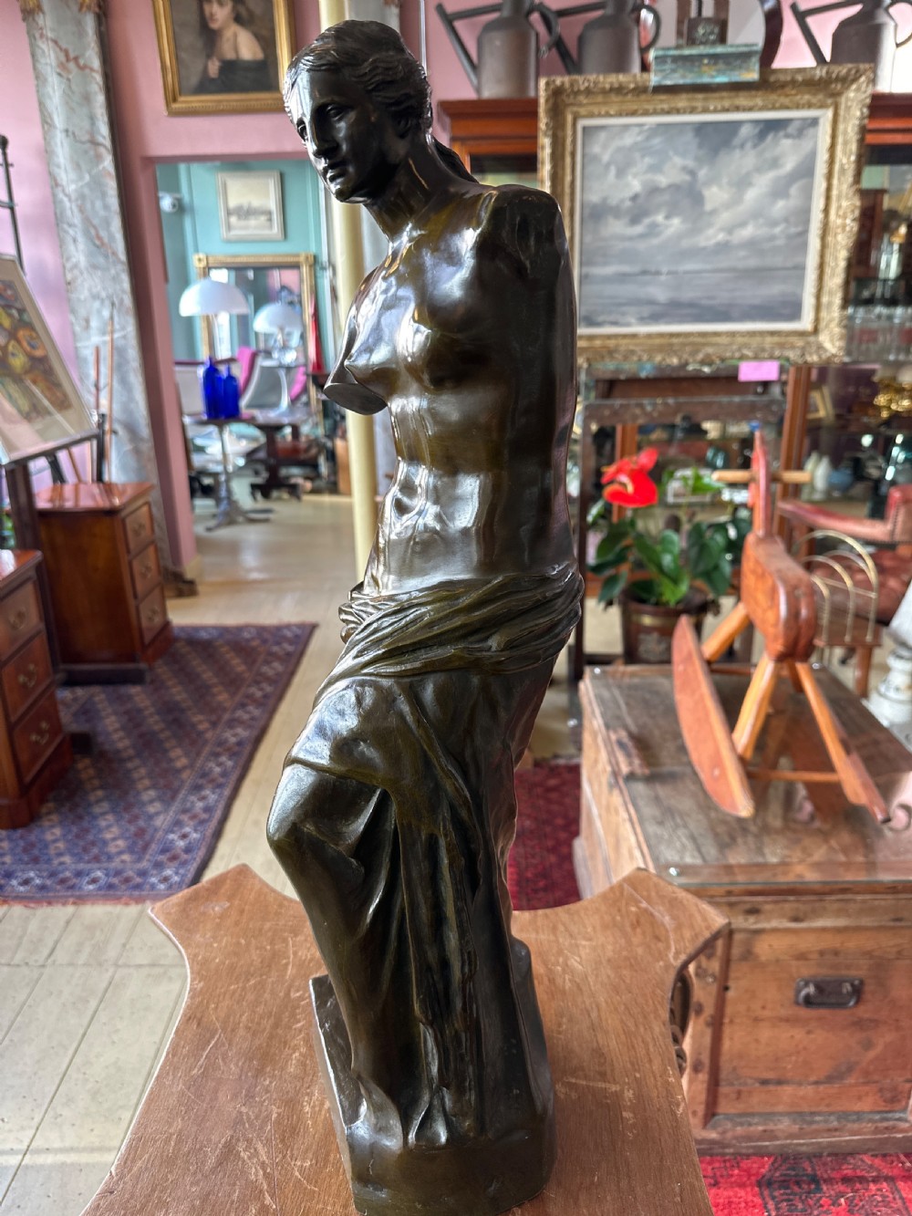 A 19th-century dark brown bronze sculpture depicting the Venus de Milo standing on an integral rectangular base. View V