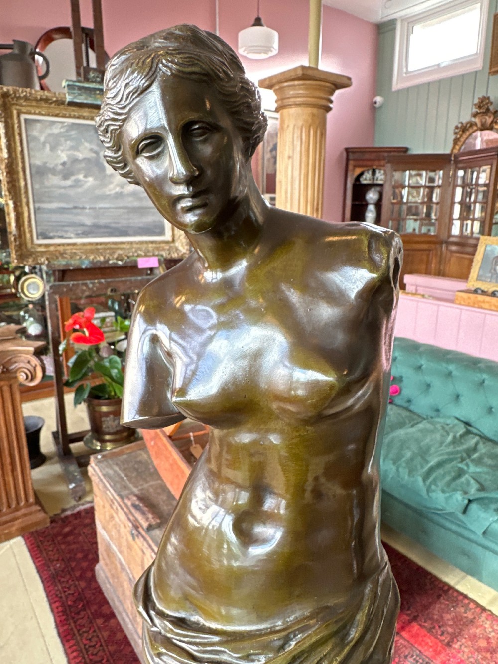 A 19th-century dark brown bronze sculpture depicting the Venus de Milo standing on an integral rectangular base. View VI