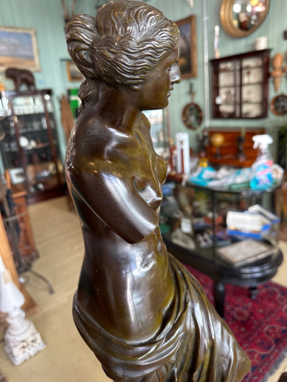 A 19th-century dark brown bronze sculpture depicting the Venus de Milo standing on an integral rectangular base. View IX