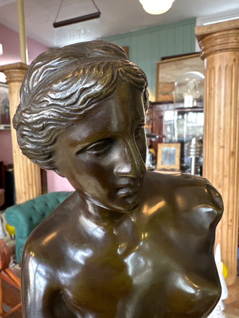 A 19th-century dark brown bronze sculpture depicting the Venus de Milo standing on an integral rectangular base. View X