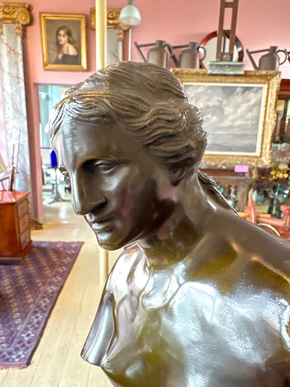 A 19th-century dark brown bronze sculpture depicting the Venus de Milo standing on an integral rectangular base. View XI