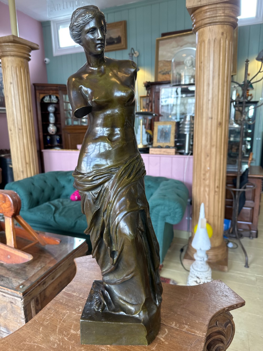 A 19th-century dark brown bronze sculpture depicting the Venus de Milo standing on an integral rectangular base. View XIV