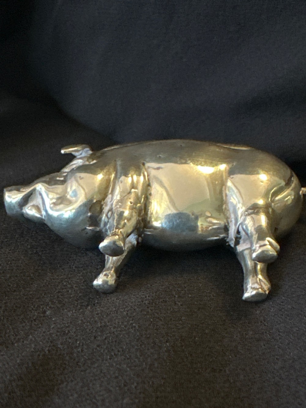 An Edwardian sterling silver pin cushion modelled in the shape of a standing pig with a fabric insert and visible hallmarked stamps on its side. View VII