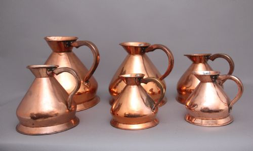 A Set of Six Highly Decorative 19th Century Copper Measuring Jugs