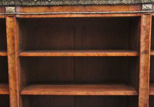 fig 1. A nineteenth-century low breakfront open bookcase crafted from burr walnut with gilt-bronze ormolu mounts along the top border and base.