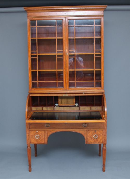 A 19th-century satinwood cylinder bureau bookcase featuring upper glazed doors, a roll-top writing section, lower drawers, and turned fluted legs. View II