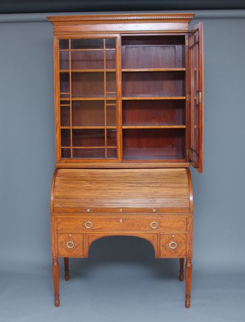 A 19th-century satinwood cylinder bureau bookcase featuring upper glazed doors, a roll-top writing section, lower drawers, and turned fluted legs. View VI